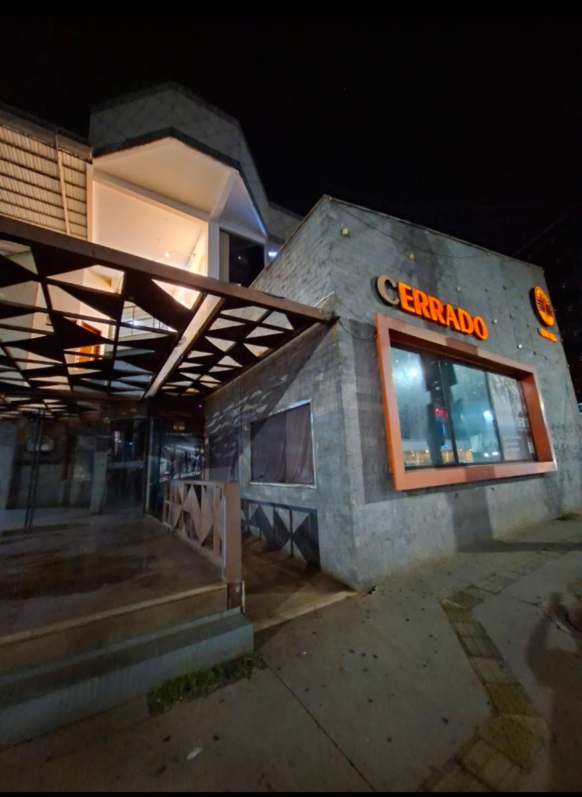 Fachada da Cerrado Cervejaria à noite, com letreiro luminoso